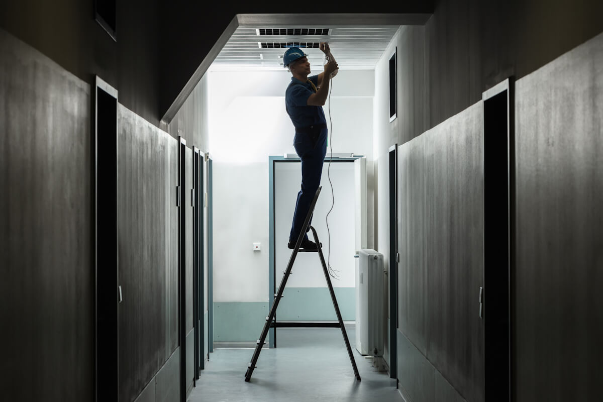 Lena Lighting  instalator sprawdzający fazy w korytarzu