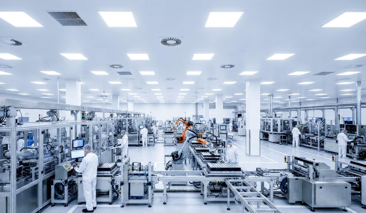 Wnętrze fabryki automotive z pracownikami przy maszynach, gdzie odpowiednie oświetlenie wspiera jakość i bezpieczeństwo pracy