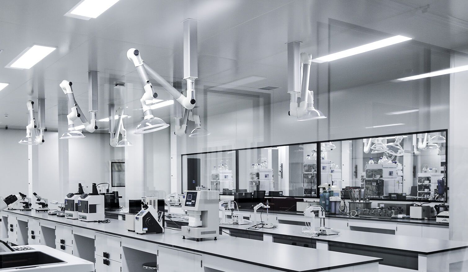 Laboratorium z białymi ścianami, nowoczesnym sprzętem i oświetleniem, stworzonym dla przemysłu farmaceutycznego