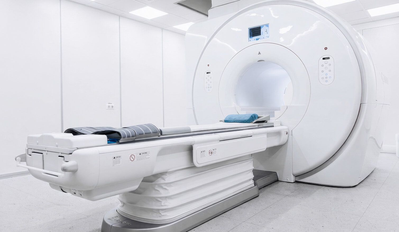 Biała sala z urządzeniem MRI, w której zastosowano lampę Lumedic, tworzącą spokojne i funkcjonalne oświetlenie